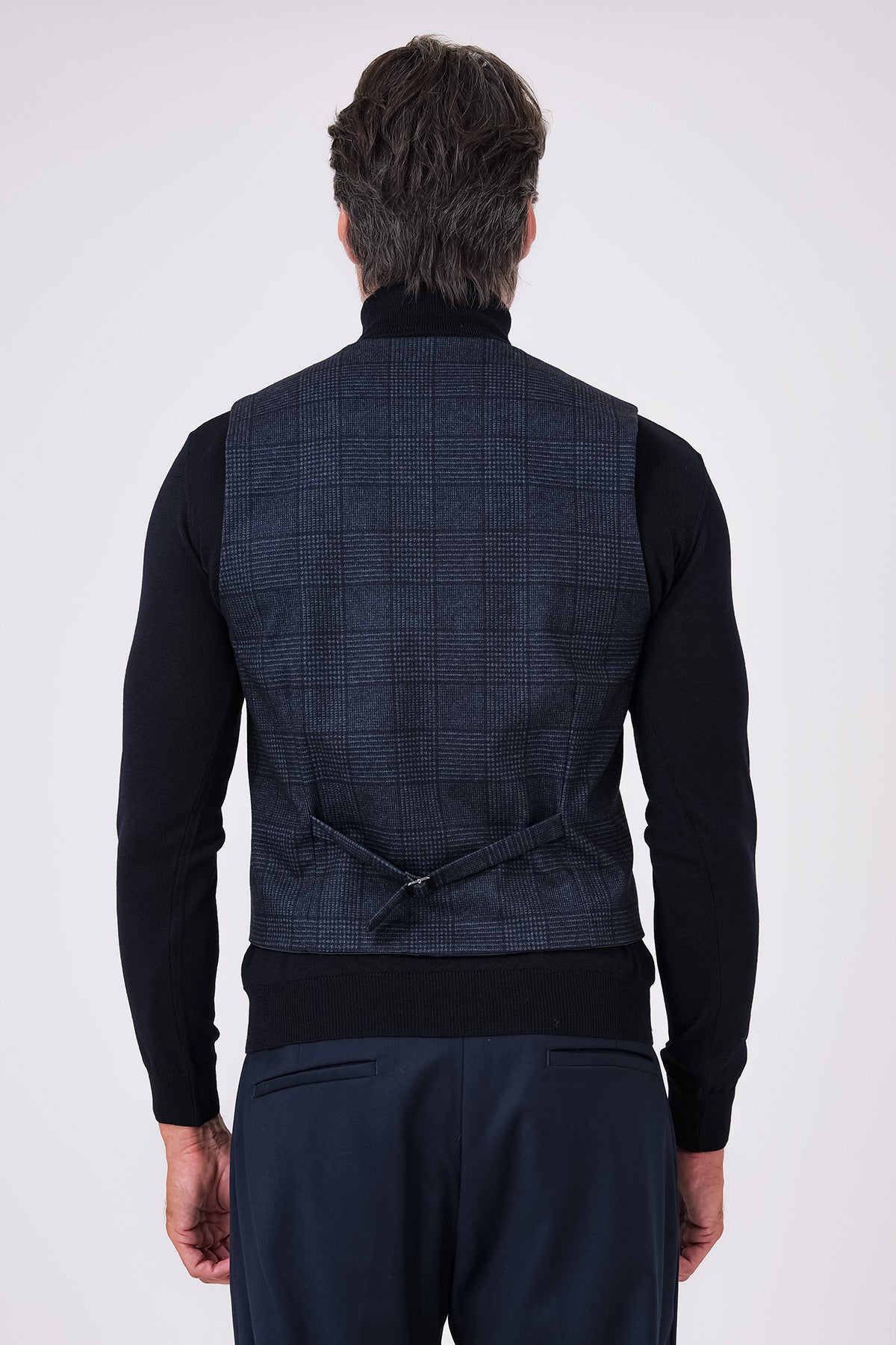 Retro del gilet blu in principe di galles indossato, con cinturino regolabile