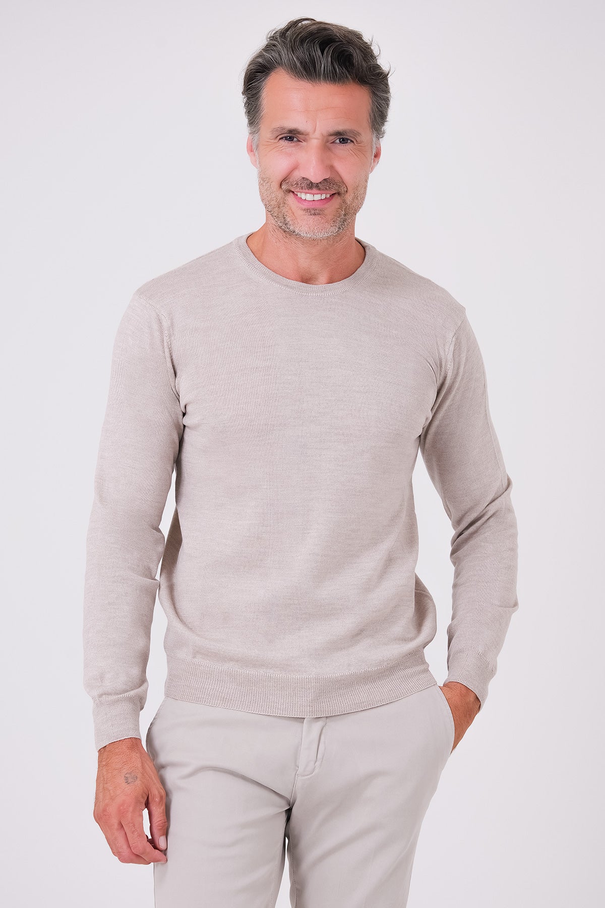 Maglia girocollo beige a manica lunga in lana merinos indossata, vista frontale