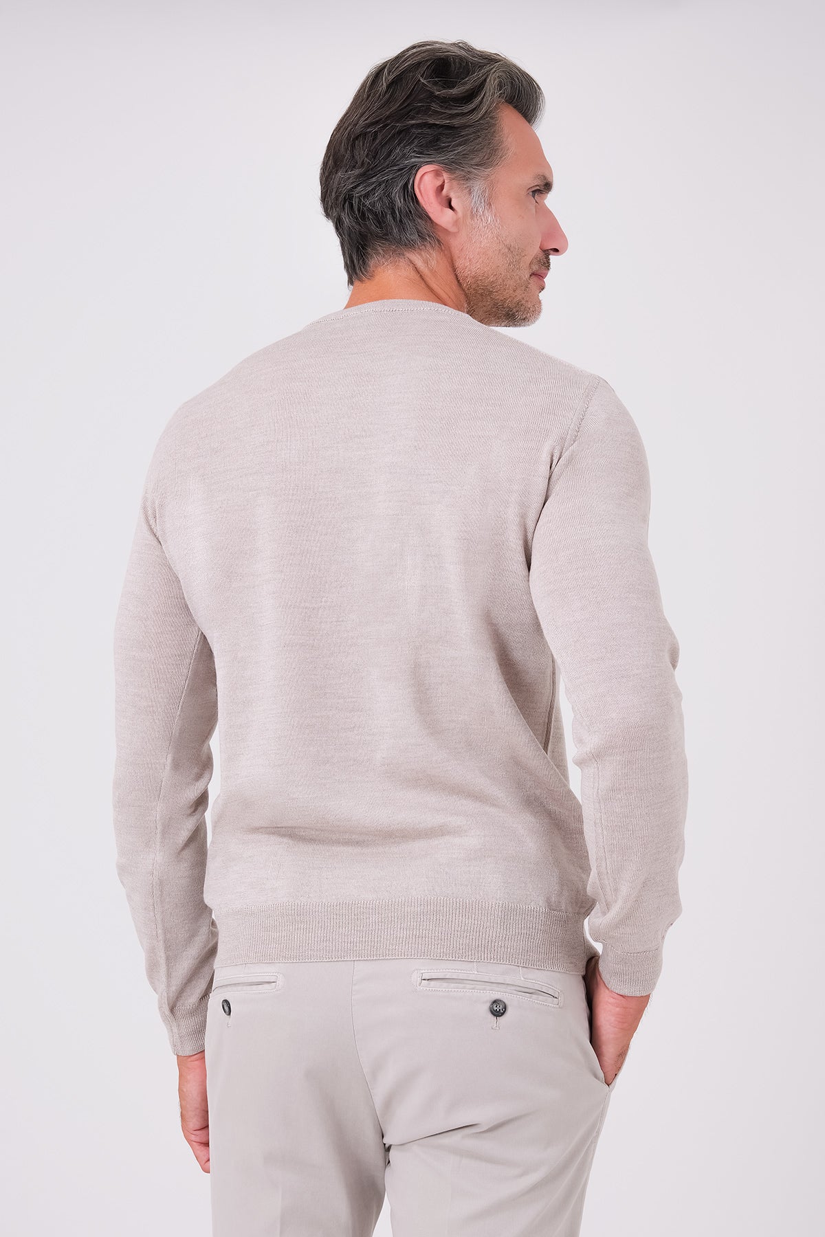 Maglia girocollo beige a manica lunga in lana merinos indossata, vista posteriore