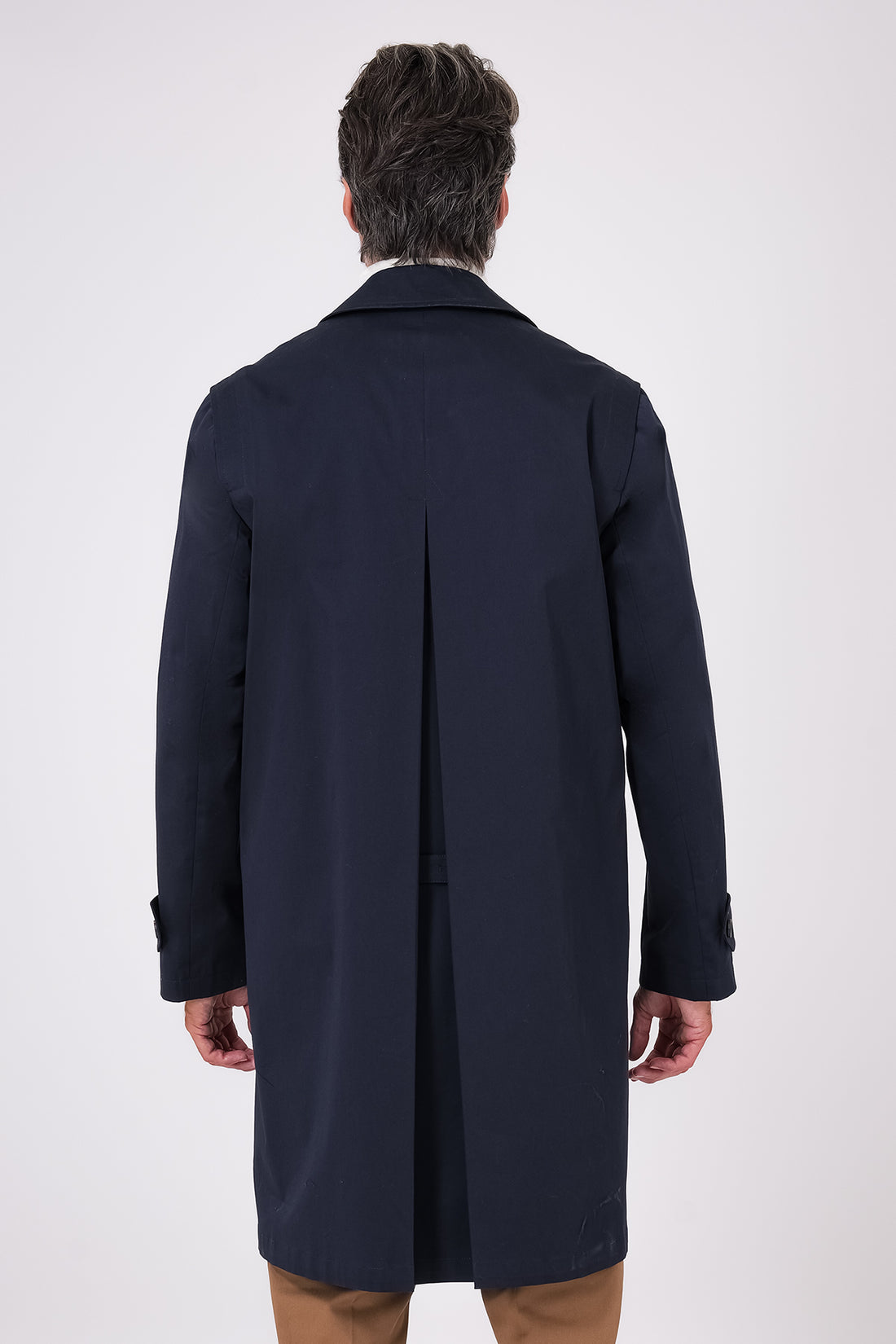 Vista frontale dell'impermeabile blu navy indossato, con collo a camicia e bottoni sul davanti