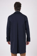 Vista posteriore dell'impermeabile blu navy indossato, con piegone centrale sul retro