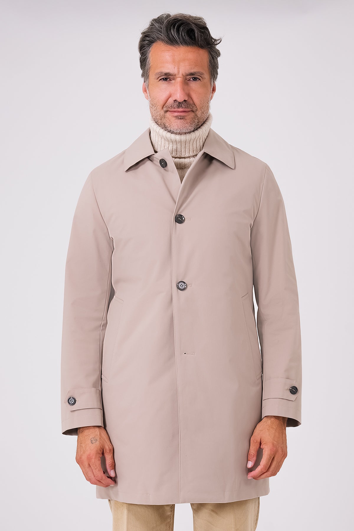 Front view of a beige raincoat with a shirt collar and button fastening on a model