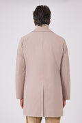 Back view of the beige raincoat with a central vent on a model
