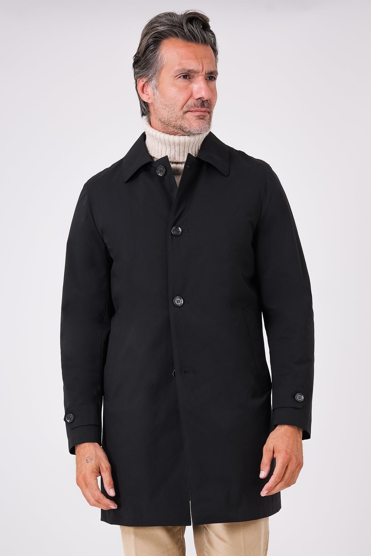 Front view of a black raincoat with a shirt collar and front buttons on a model