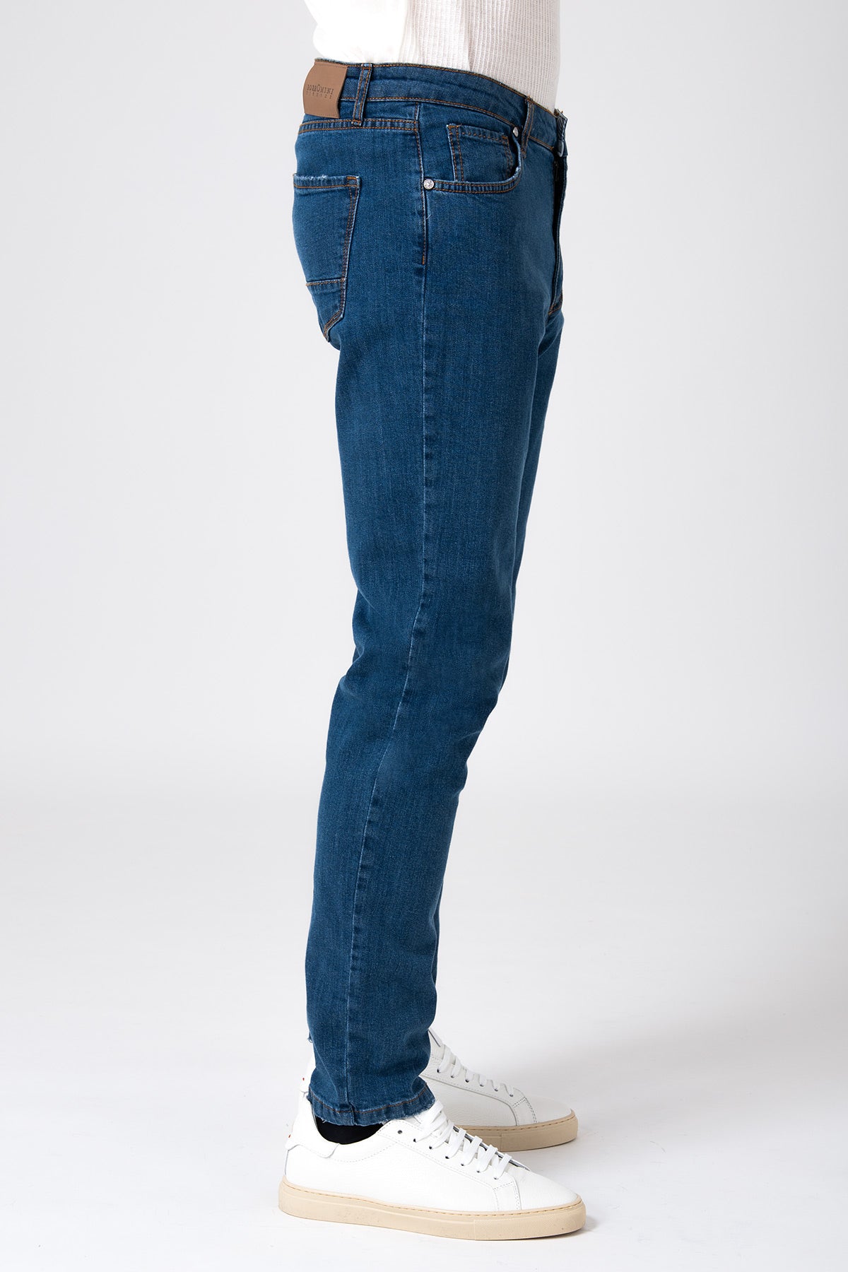 Uomo che indossa jeans cinque tasche color denim scuro, vista posteriore