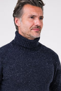 Dettaglio del collo alto a costine della maglia dolcevita blu navy in misto lana indossata