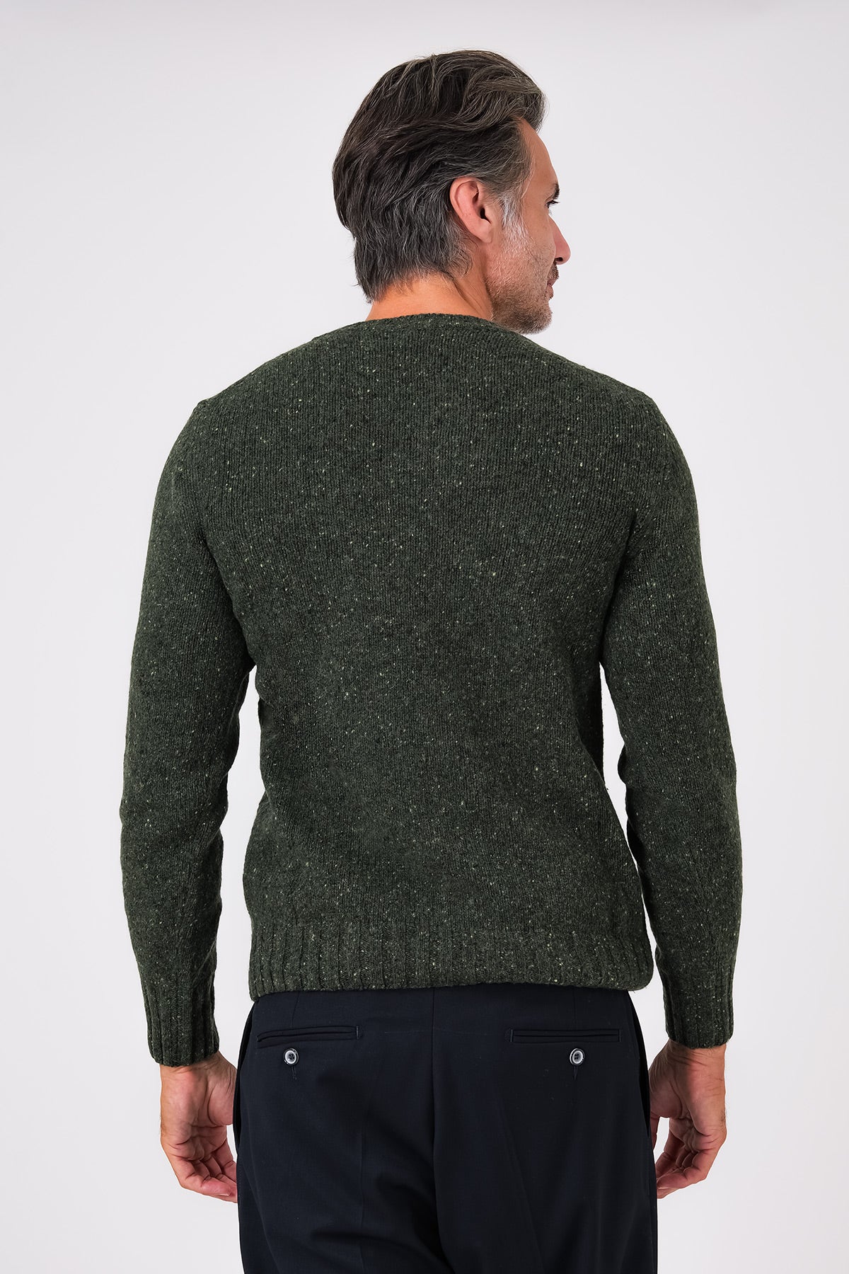 Vista posteriore della maglia girocollo verde in lana e poliammide indossata