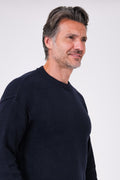 Vista di profilo della maglia girocollo blu navy in misto lana indossata
