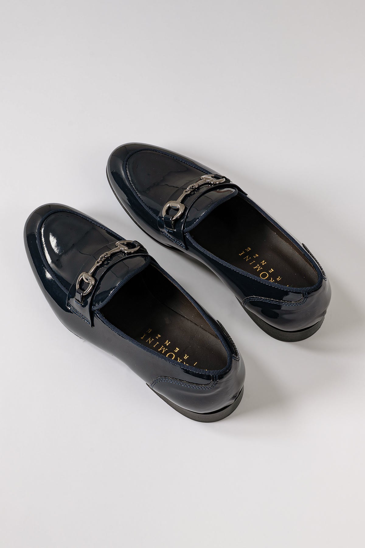 Patent leather loafer with a buckle in blue, front view