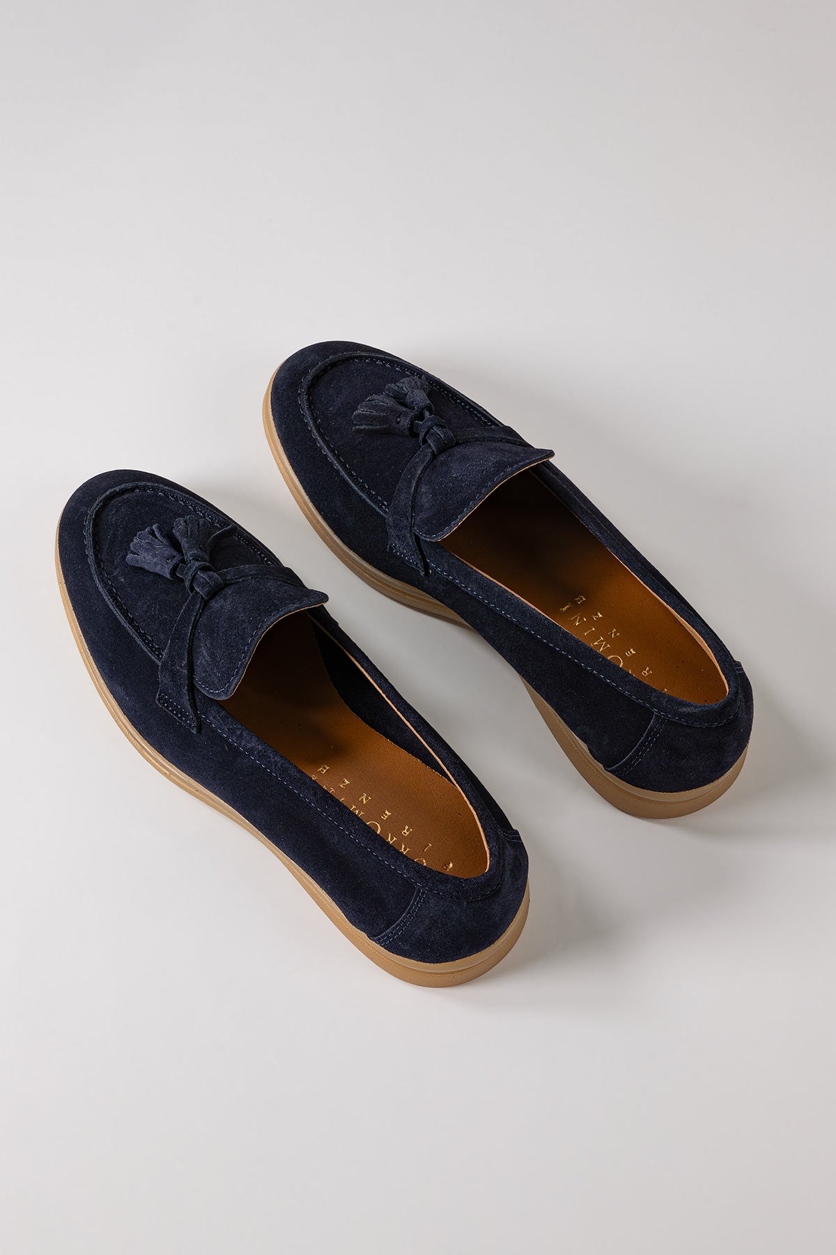 Front view of blue suede loafers with tassels