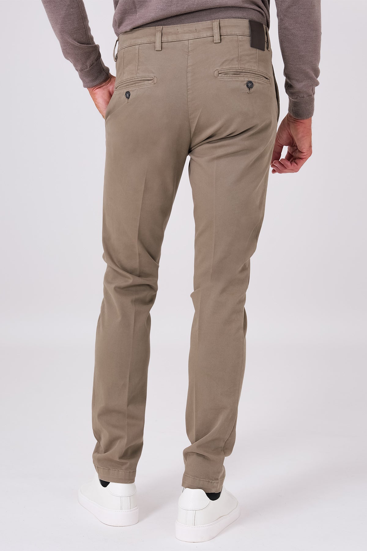 Back view of mud brown stretch cotton trousers on a model