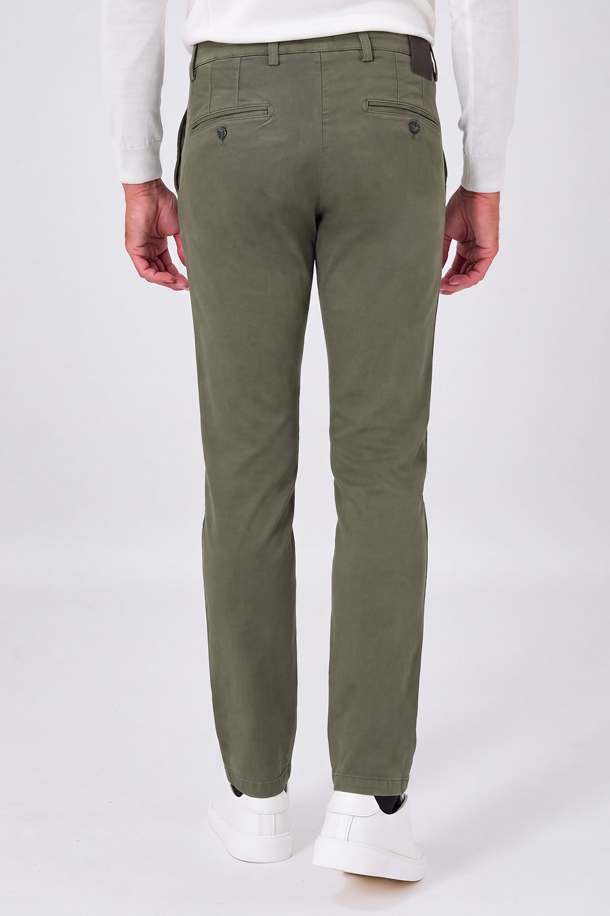Back view of military green stretch cotton trousers on a model, with welt pockets