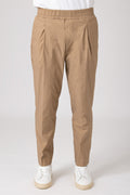 Man wearing beige carrot pants with elastic waist front view