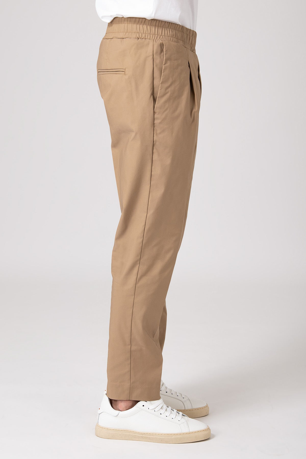 Man in profile wearing beige elastic waist carrot pants