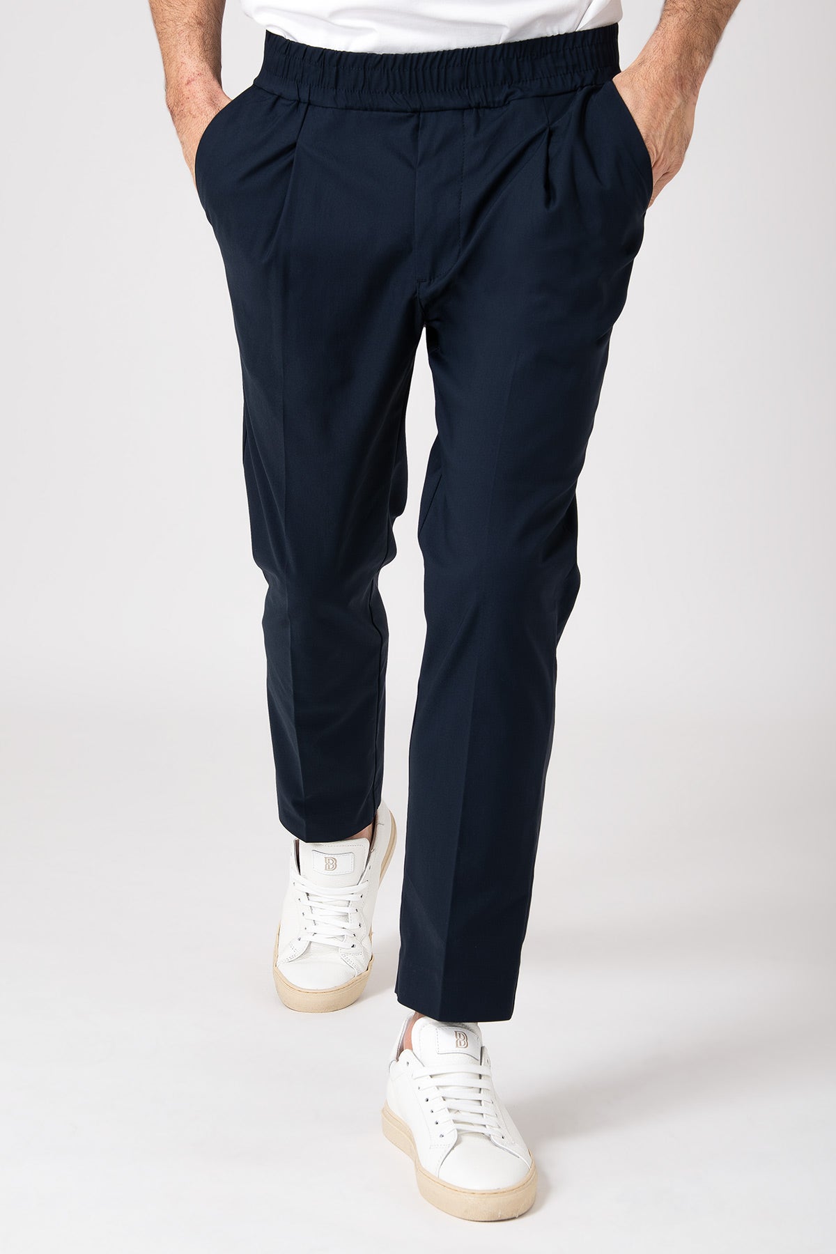 Man wearing blue carrot pants with elastic waist front view
