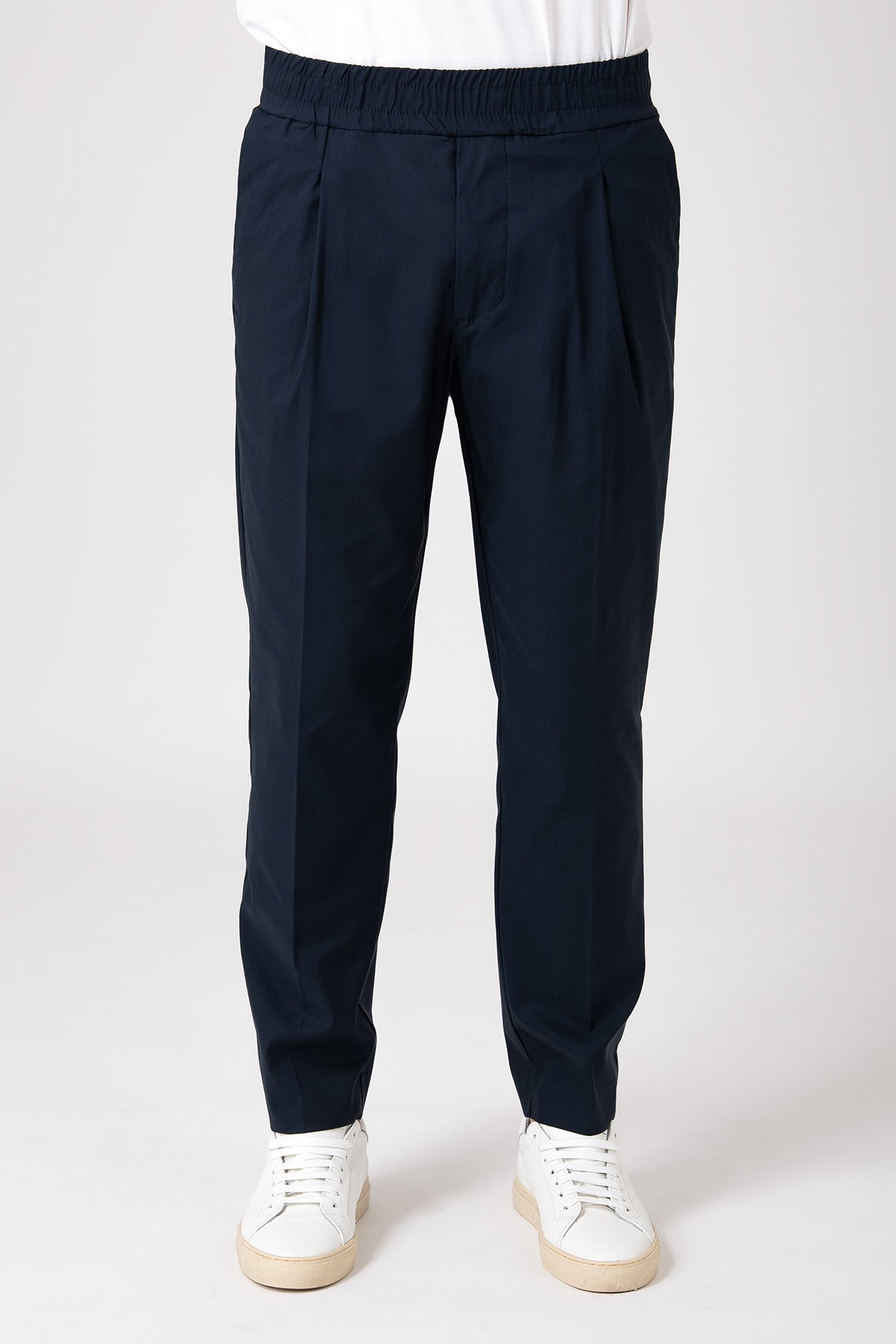 Man wearing navy blue carrot pants with elastic waist front view