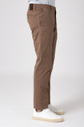 Side view of a man wearing stretch cotton pants in mud color