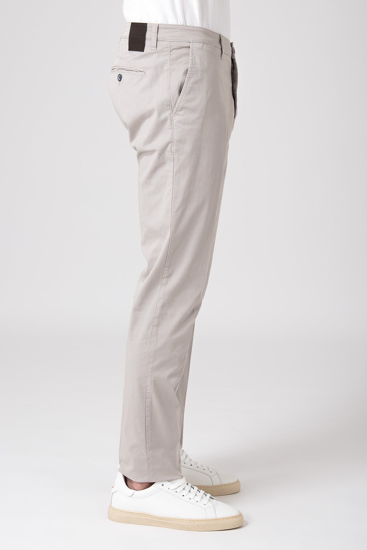Man wearing sand stretch cotton pants with white sneakers side view