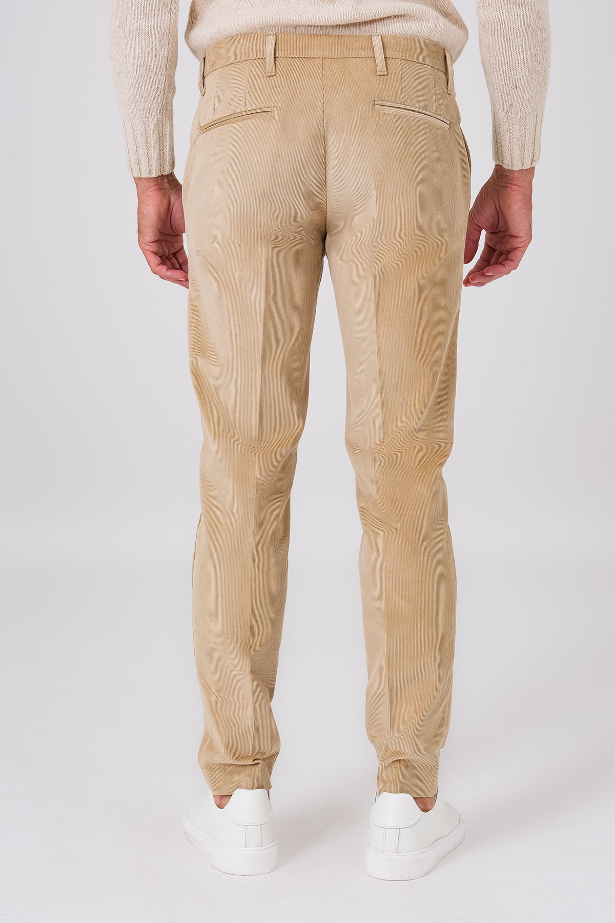Vista posteriore del pantalone chino beige in velluto di cotone indossato