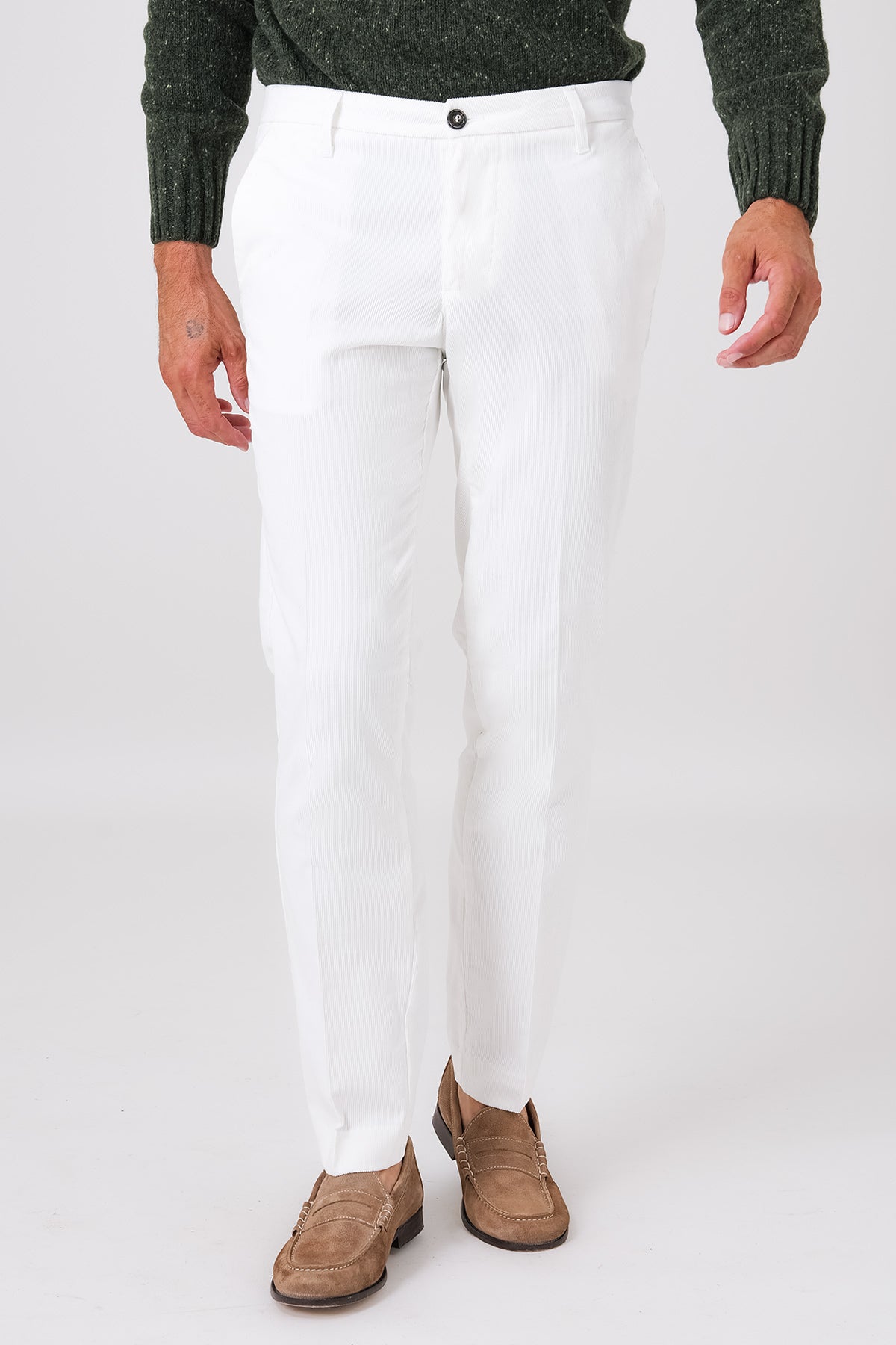 Vista frontale del pantalone chino in velluto di cotone bianco indossato