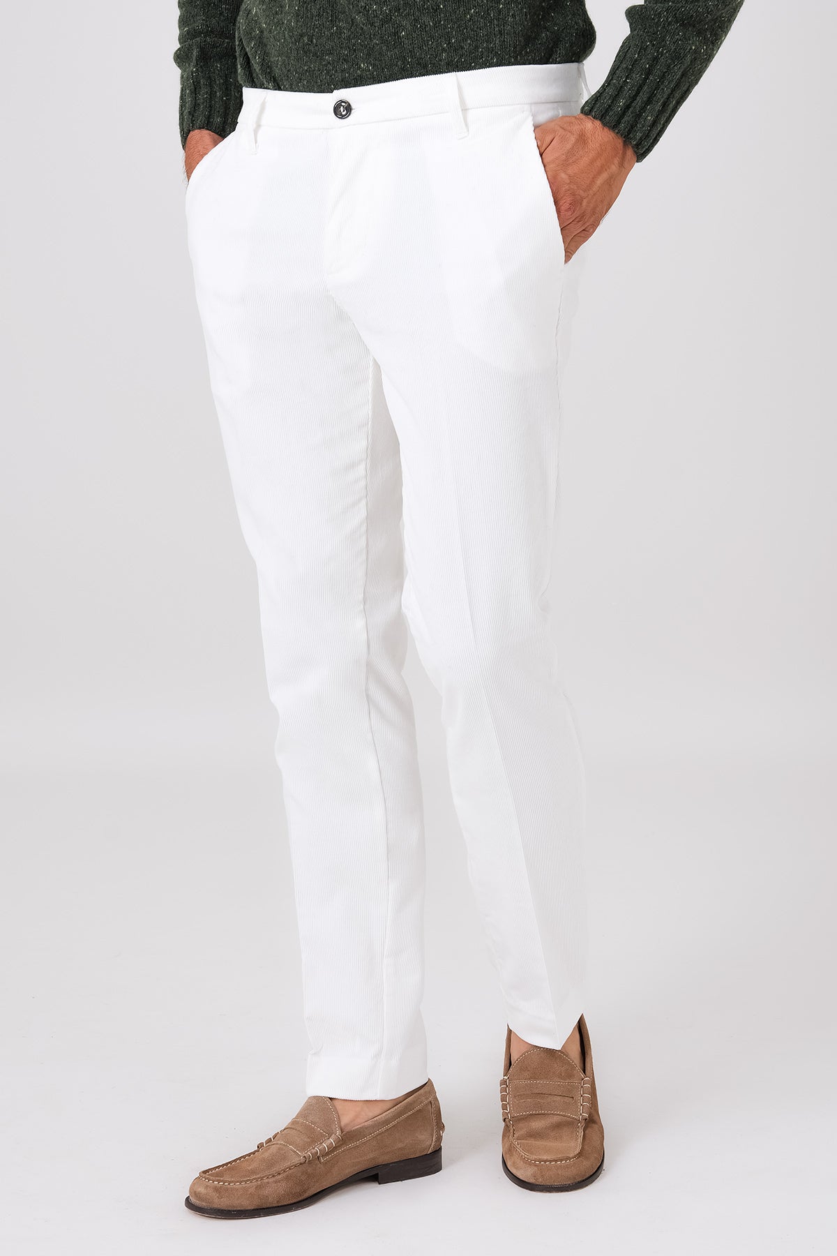Vista frontale del pantalone chino in velluto di cotone bianco indossato