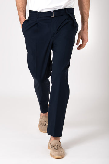 Man wearing blue pants with strap and pence, frontal view in motion