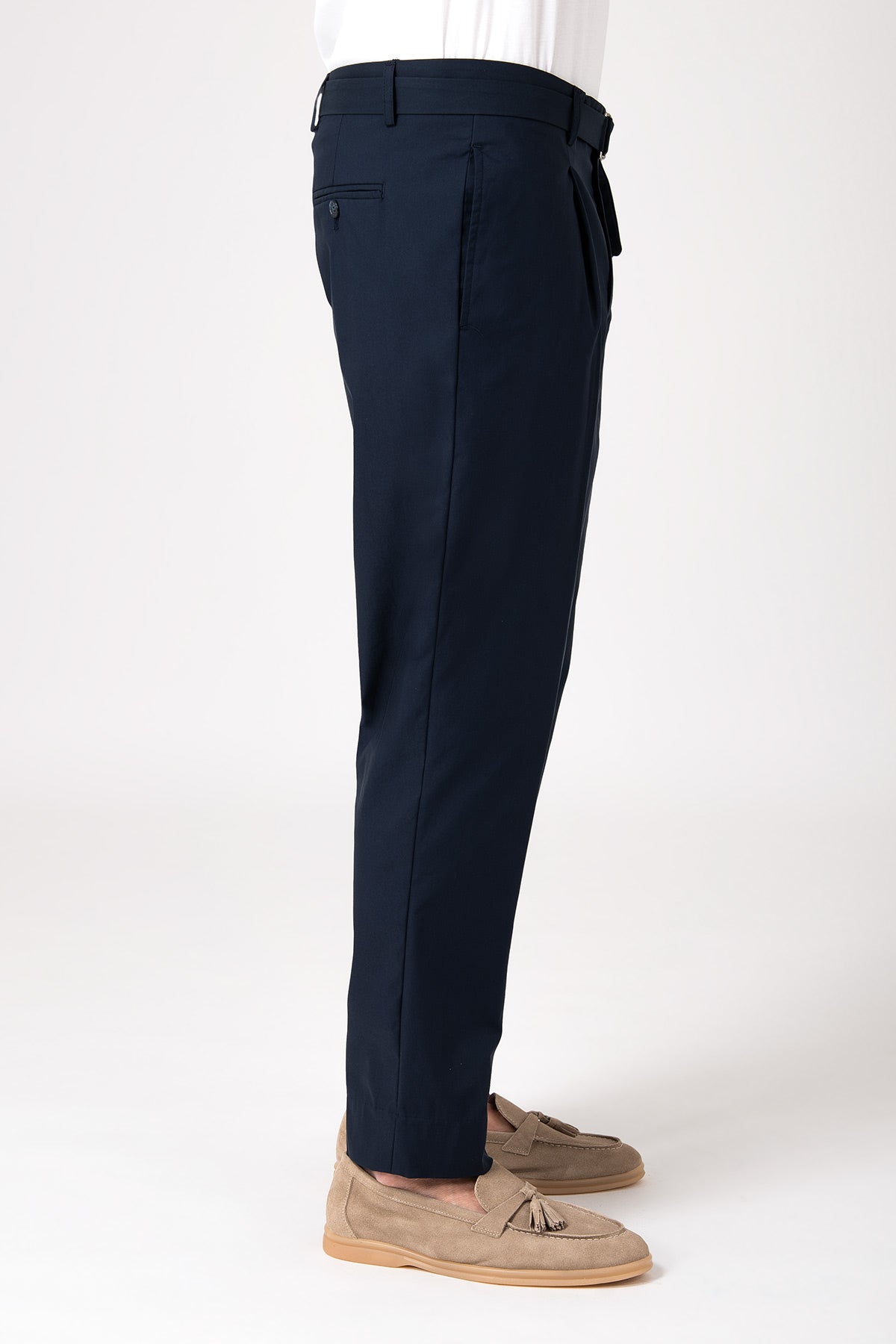 Man wearing dark brown pleated trousers with side straps, side view