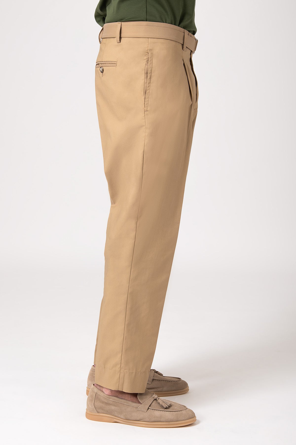 Uomo che indossa un pantalone con cinturino e pence color beige, vista di profilo