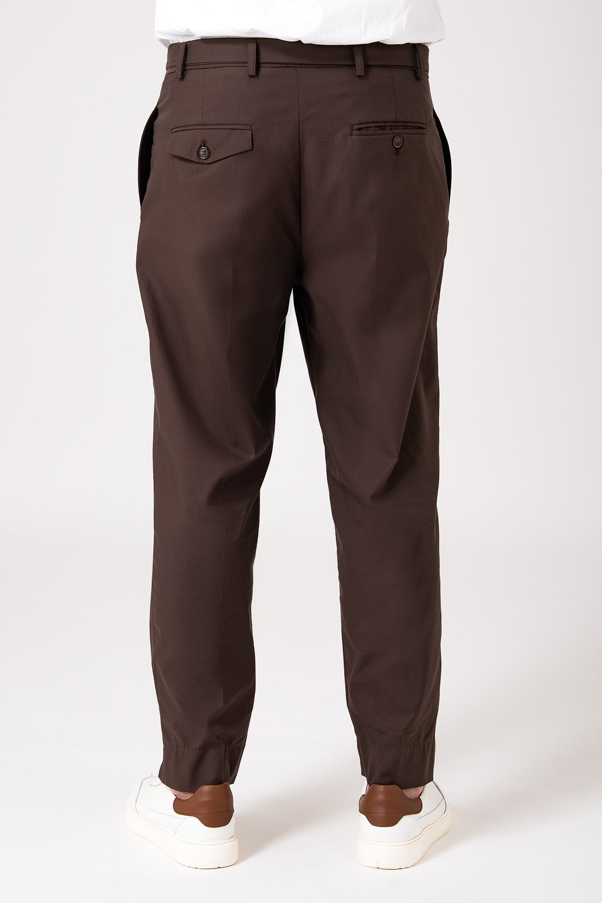 Man wearing dark brown pants with belt and pence, rear view