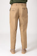Back view of man wearing beige trousers with strap and panel detail