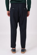 Back view of blue trousers on a model, with welt pockets and buttons