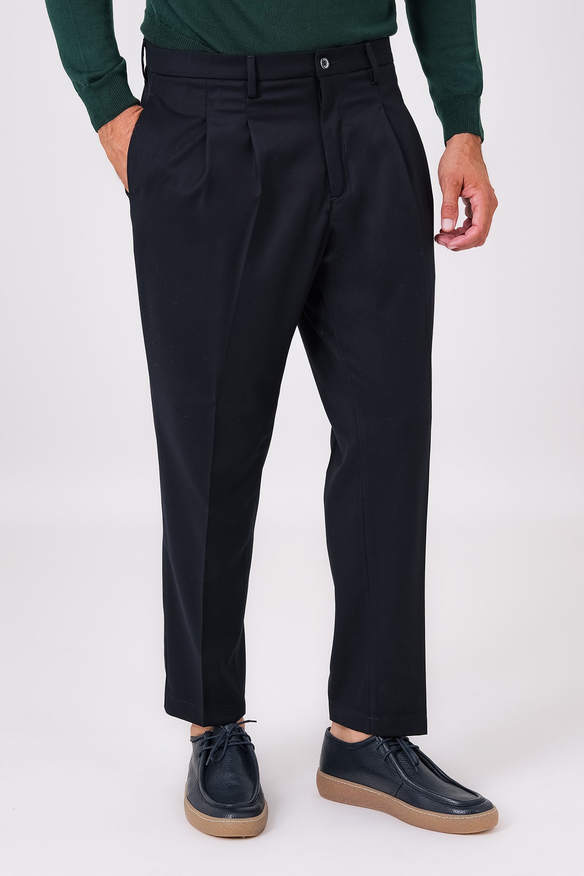 Front view of blue double-pleated trousers on a model