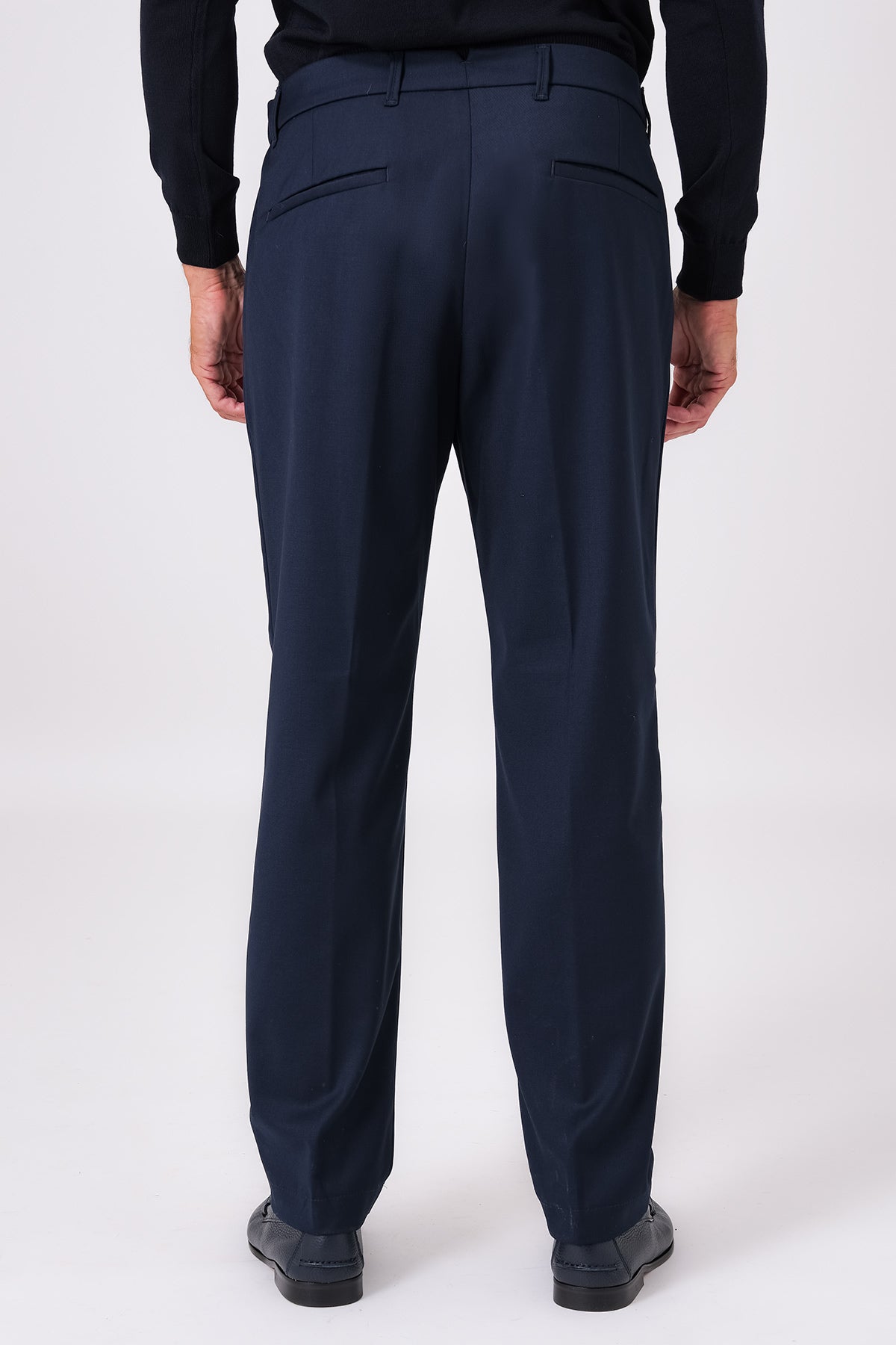 Vista posteriore del pantalone blu indossato, con tasche a filetto e passanti per cintura