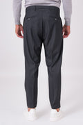 Rear view of smoke grey trousers with welt pockets on a model