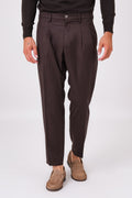 Front view of dark brown double-pleated trousers on a model