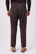 Rear view of dark brown trousers on a model with buttoned jet pockets