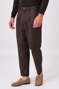 Front view of dark brown double-pleated trousers on a model