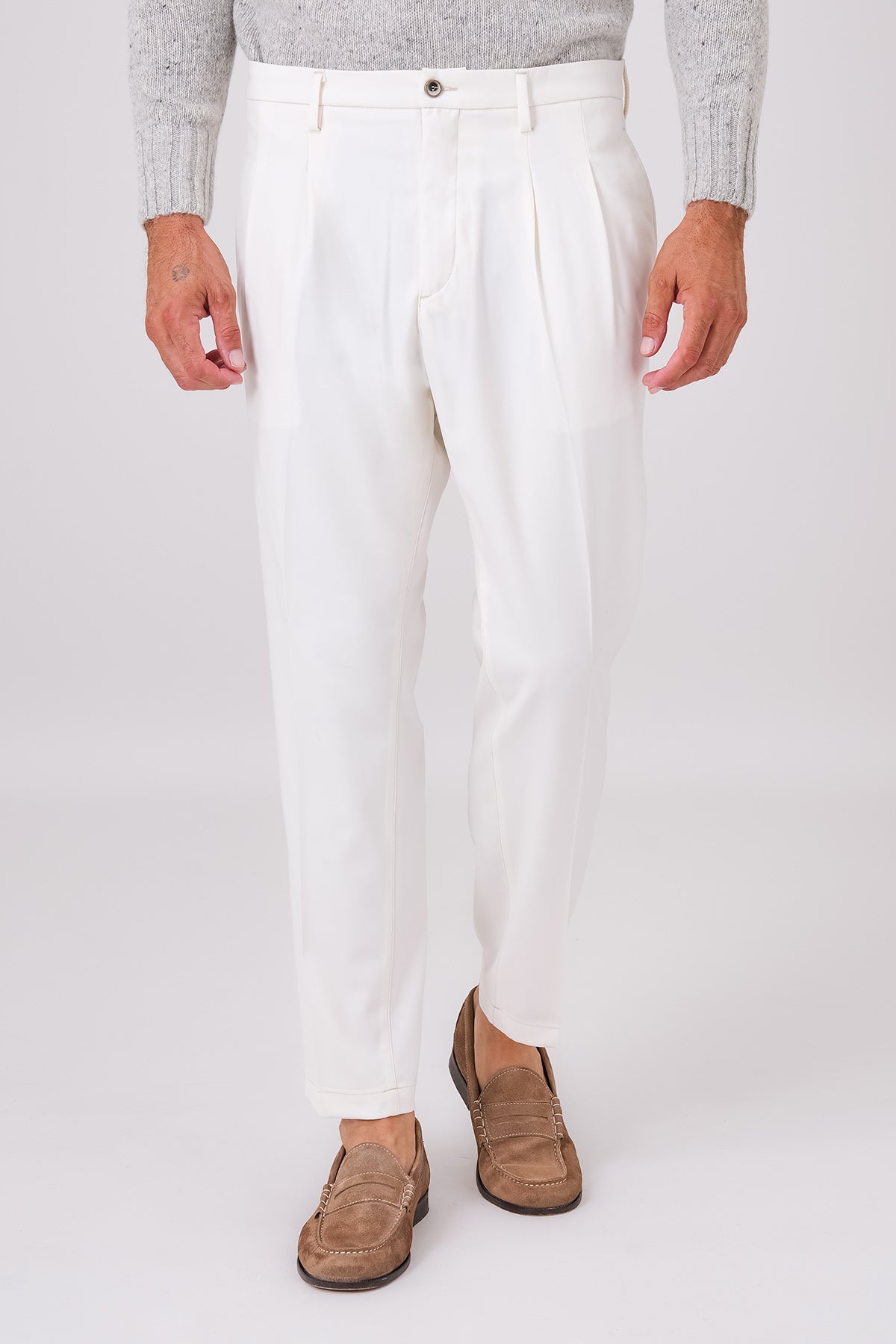 Front view of cream double-pleated trousers on a model
