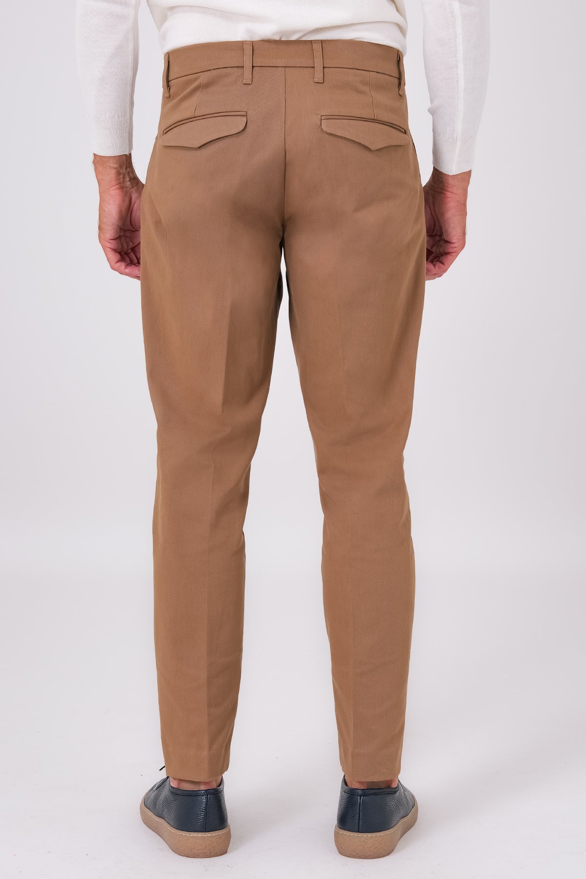 Back view of mud brown stretch cotton trousers on a model