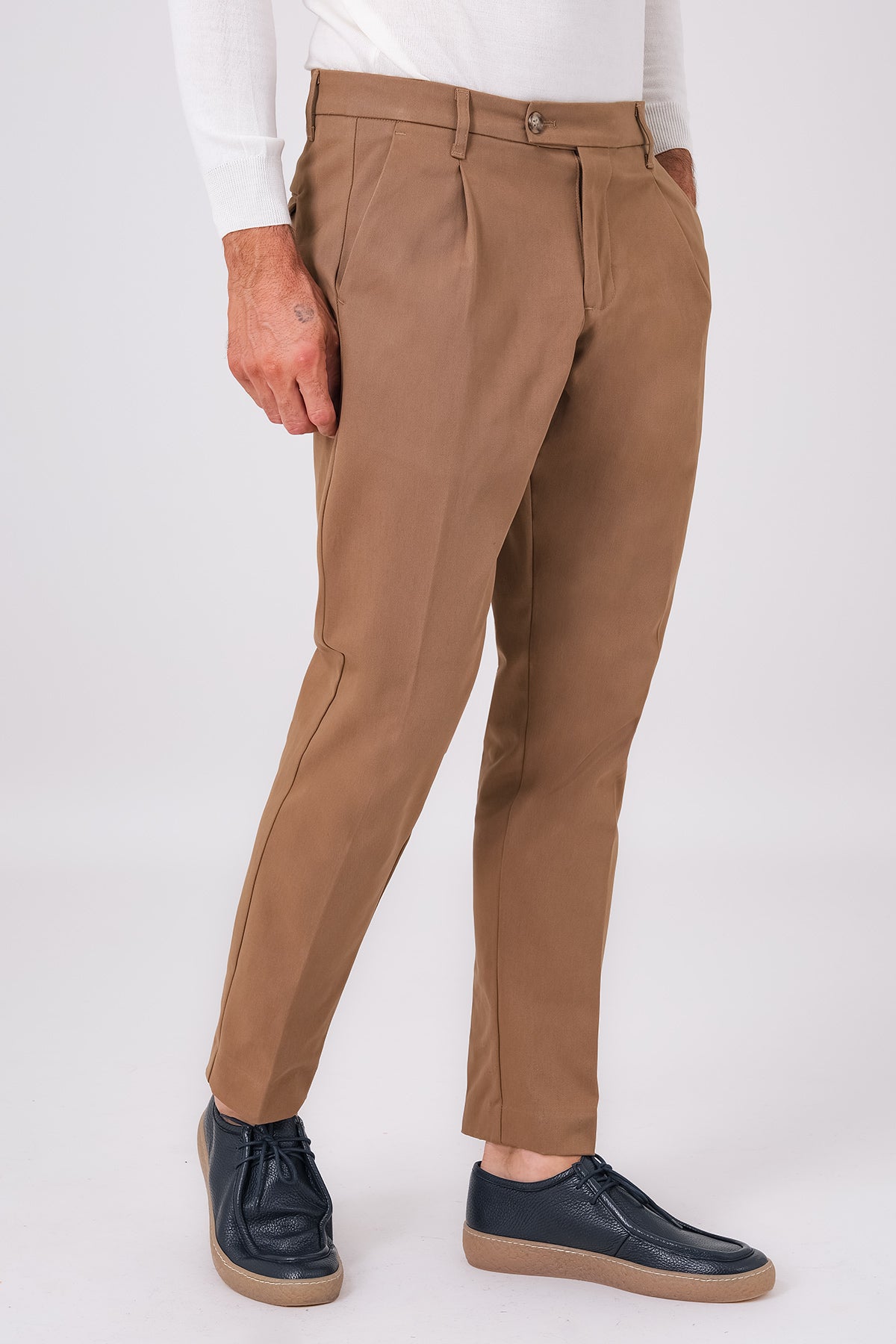 Front view of mud brown stretch cotton pleated trousers on a model