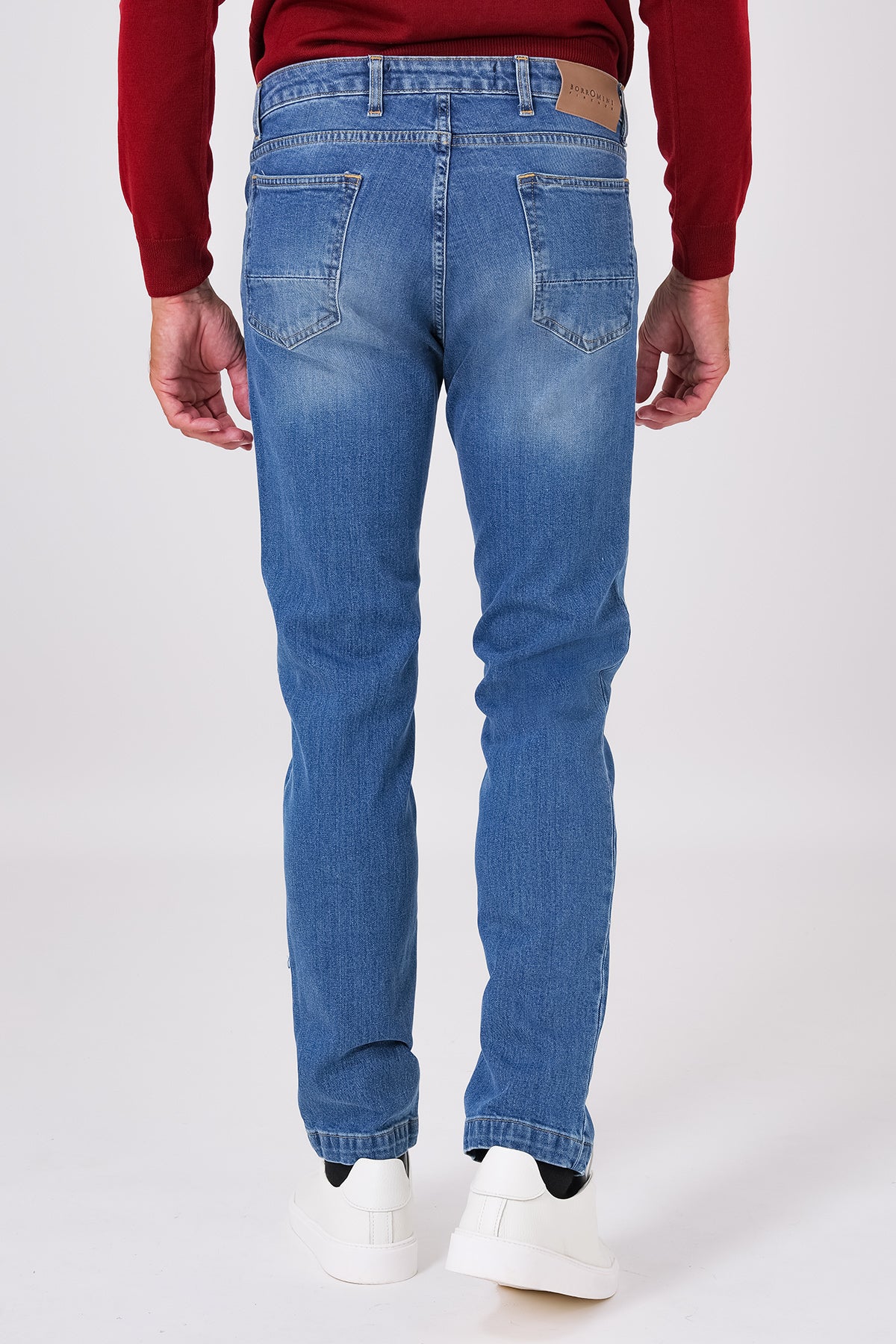 Back view of five-pocket denim trousers on a model, with patch pockets