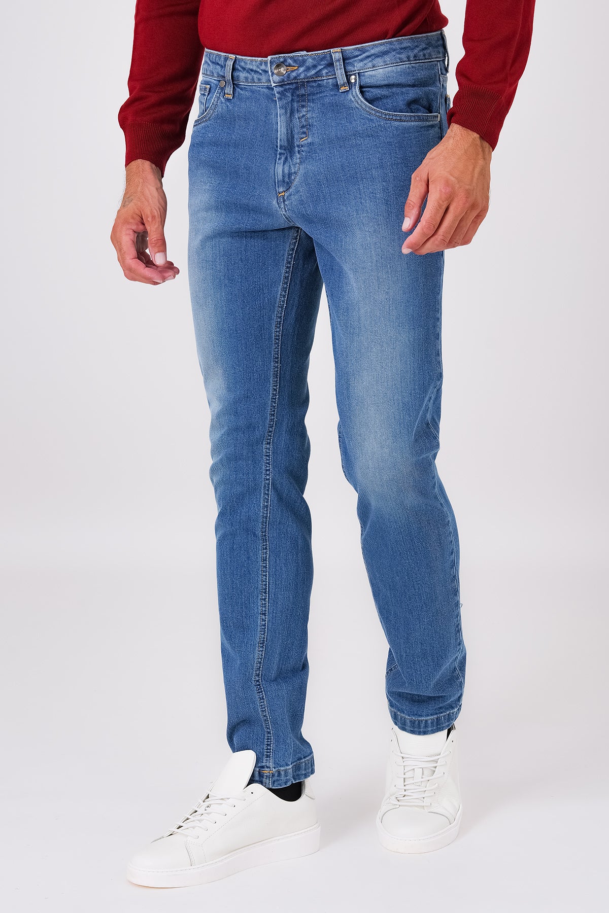 Front view of denim blue five-pocket denim trousers on a model
