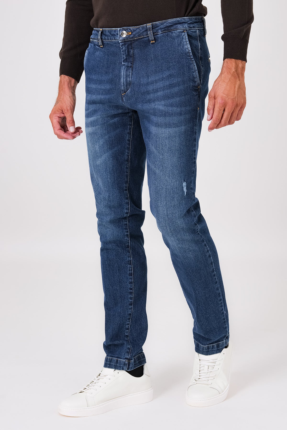 Medium-wash denim trousers with slant pockets on a model, front view