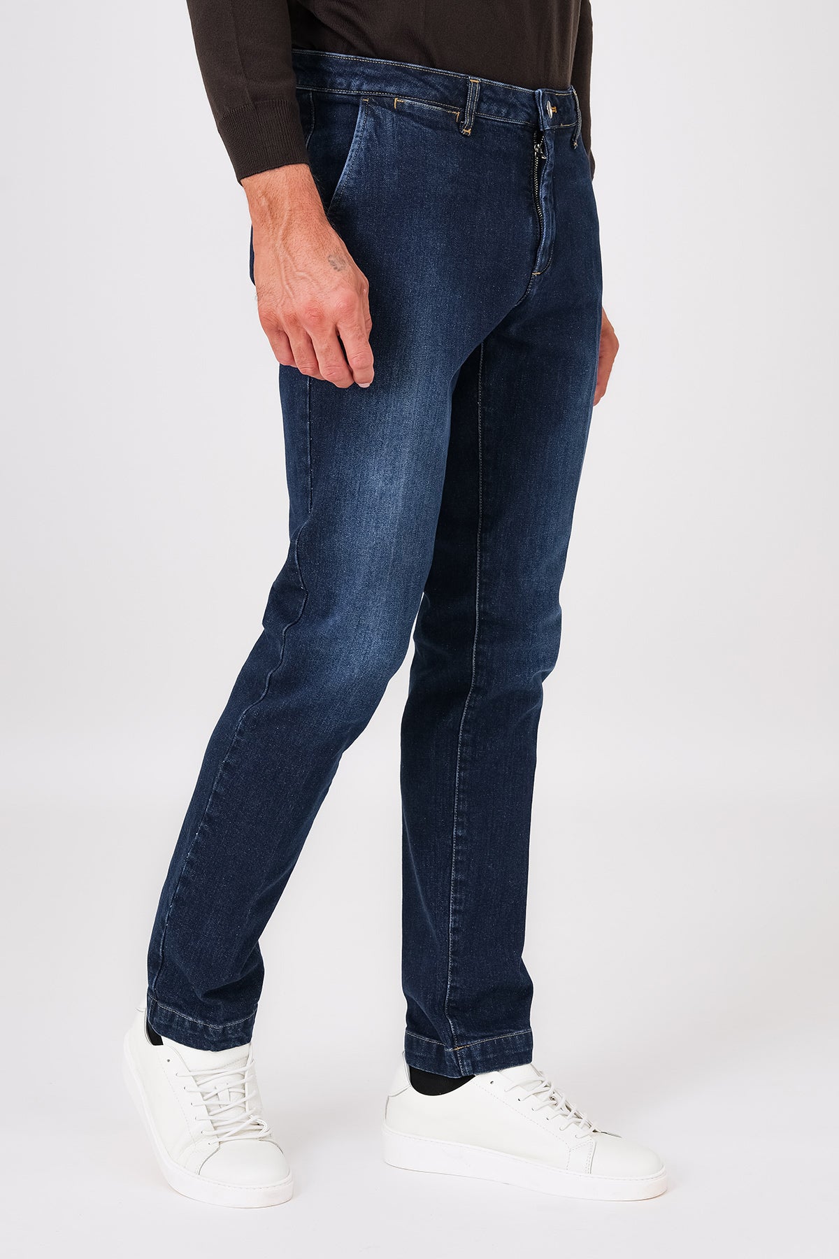 Side view of dark denim trousers with slant pockets on a model