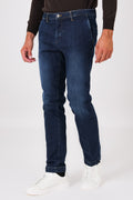 Front view of dark denim trousers with slant pockets on a model