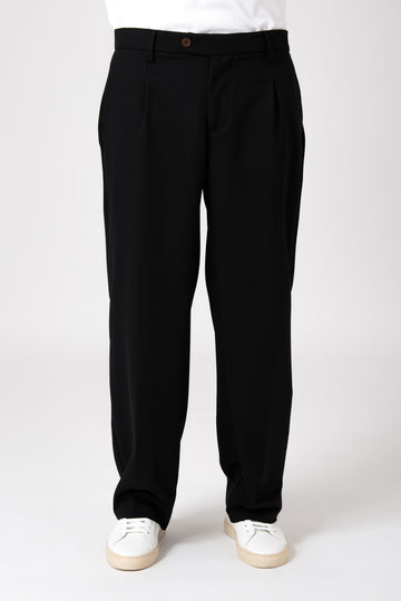 Uomo che indossa un pantalone largo nero fluido con vista frontale