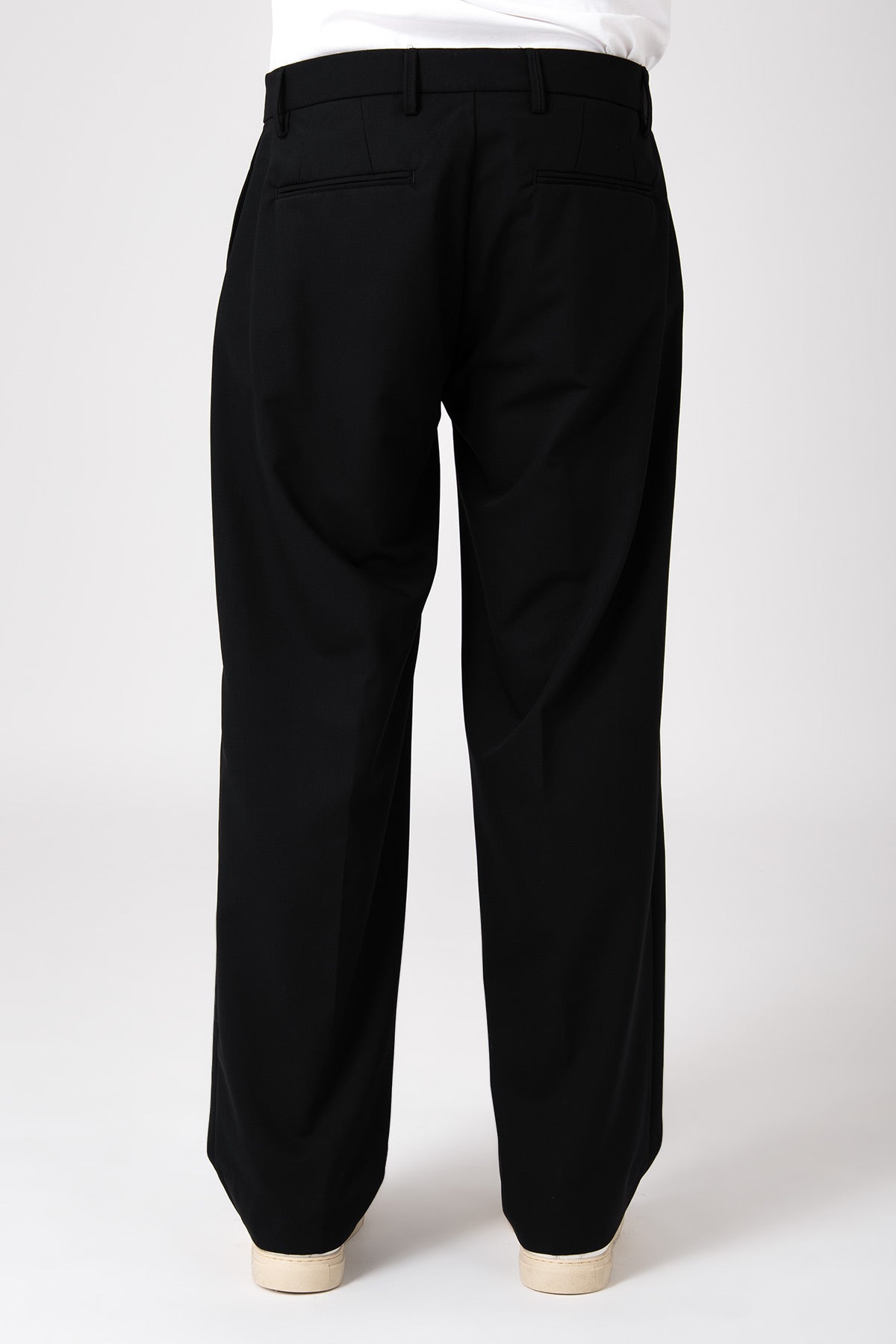 Vista posteriore di una modella che indossa un pantalone largo nero fluido