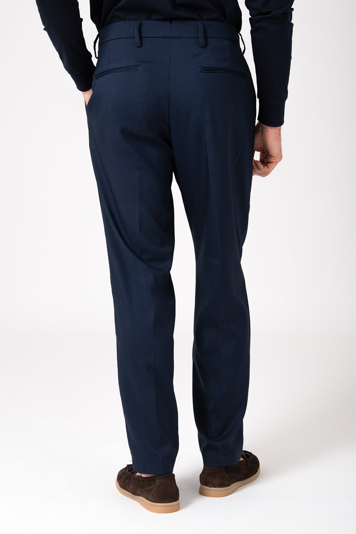 Man wearing blue wool French pleated trousers, back view