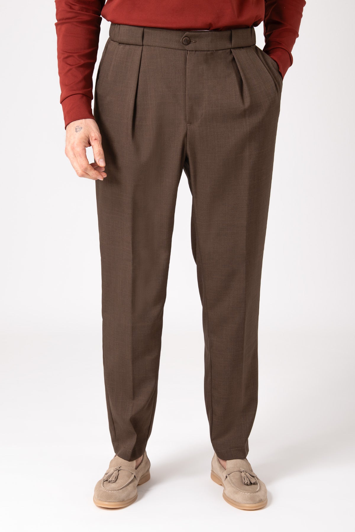 Man wearing brown wool French Penny trousers front view with hands in pockets