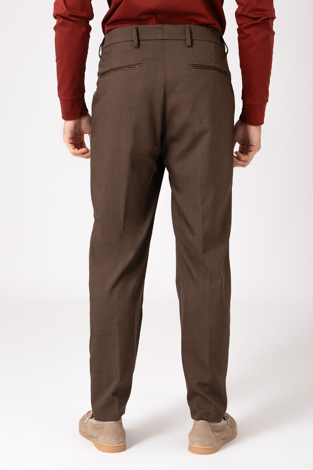 Man wearing brown wool French pence trousers seen from behind